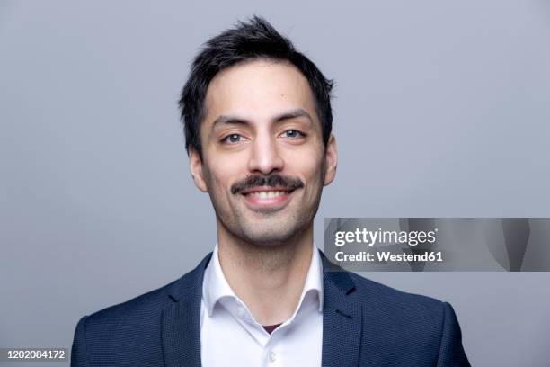 portrait of smiling businessman with moustache - schnauzer stock-fotos und bilder