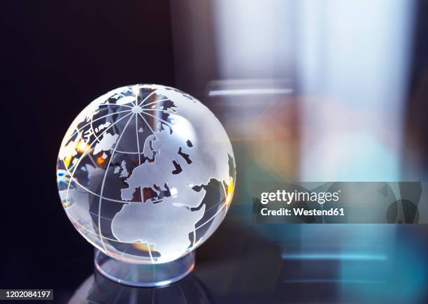 glass globe representing international business and trade - mundo de cristal fotografías e imágenes de stock