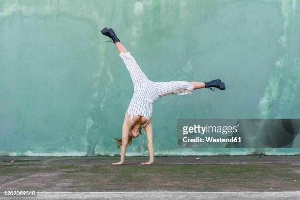 young woman doing handstand - piernas en el aire fotografías e imágenes de stock