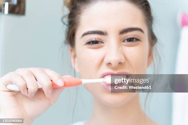 woman brushing teeth - brushing stock pictures, royalty-free photos & images