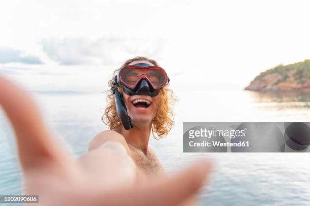 young man with snorkel making a face on the beach - dykmask bildbanksfoton och bilder