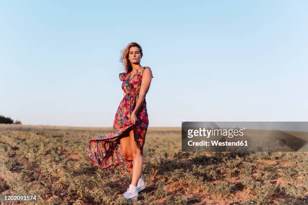 blond woman wearing summer dress with closed eyes at countryside - sommerkleid stock-fotos und bilder