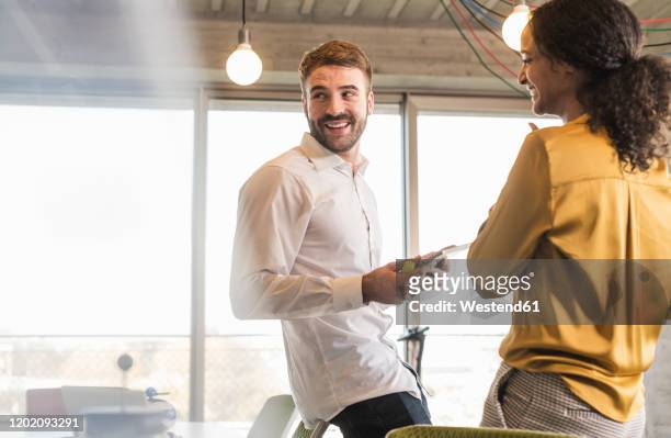smiling businessman and businesswoman having a meeting in office - founder stock pictures, royalty-free photos & images