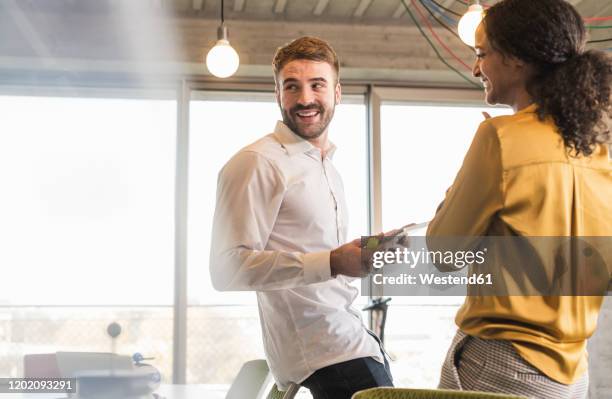 smiling businessman and businesswoman having a meeting in office - founder bildbanksfoton och bilder