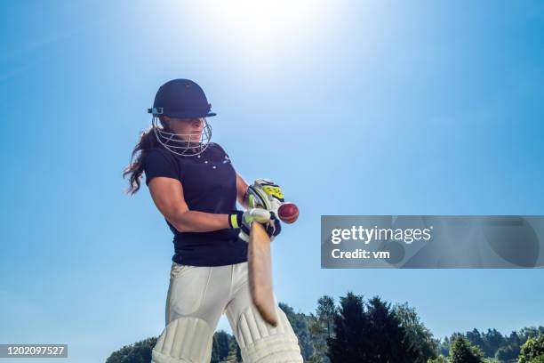 weibliche cricket-schläger schlagen den ball - cricket stock-fotos und bilder