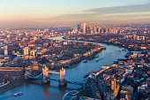 Aerial view of Tower Bridge and Canary Wharf skyline at sunset