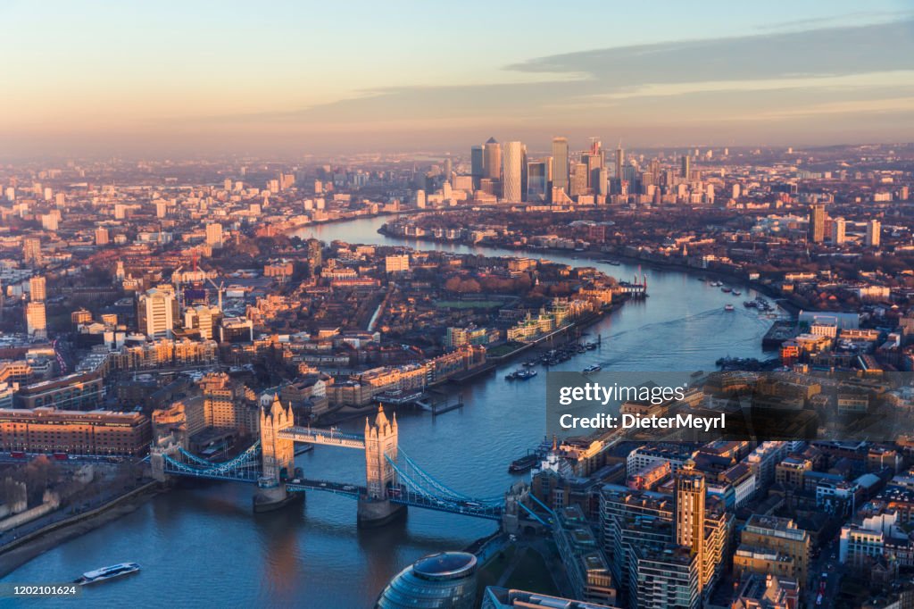 Aerial view of Tower Bridge and Canary Wharf skyline at sunset