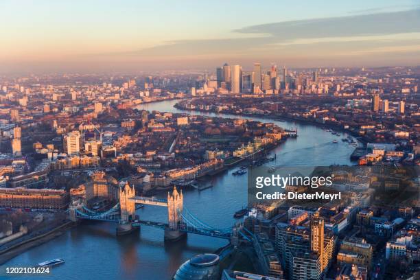aerial view of tower bridge and canary wharf skyline at sunset - london skyline stock pictures, royalty-free photos & images