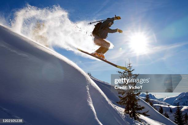 free-skifahrer, der an einem klaren sonnigen wintertag frischen pulverschnee sprüht - alpe d'huez stock-fotos und bilder