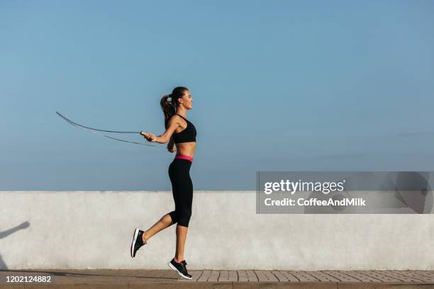 jovencita entrenando con una cuerda de salto - dar brincos fotografías e imágenes de stock