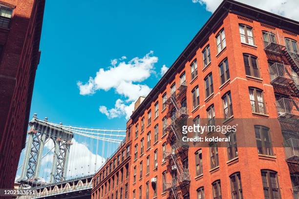 view of manhattan bridge from dumbo brooklyn against blue sky - brooklyn new york stockfoto's en -beelden