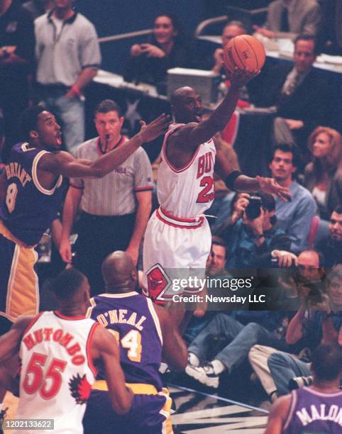 Michael Jordan of the Chicago Bulls on the East team laying the ball up in front of Kobe Bryant of the Los Angeles Lakers on the West team during the...