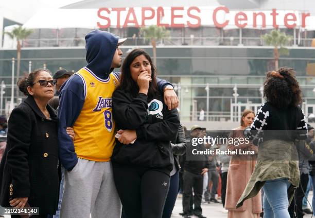 Los Angeles Lakers fans Lilian Gamez, Gabriel Gamez and Angelica Rodriguez mourn the death of retired NBA star Kobe Bryant outside the Staples Center...