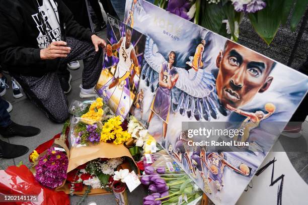 Flowers and tributes are left at a makeshift memorial for former NBA player Kobe Bryant outside the 62nd Annual GRAMMY Awards at STAPLES Center on...