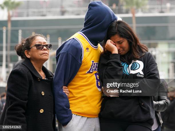 Los Angeles Lakers fans Lilian Gamez, Gabriel Gamez and Angelica Rodriguez mourn the death of retired NBA star Kobe Bryant outside the Staples Center...