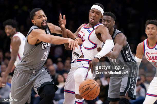 Spencer Dinwiddie and Caris LeVert of the Brooklyn Nets battle for the ball against Josh Richardson of the Philadelphia 76ers in the fourth quarter...