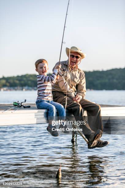 grandfather and grandson fishing at sunset in summer - kids fishing stock pictures, royalty-free photos & images