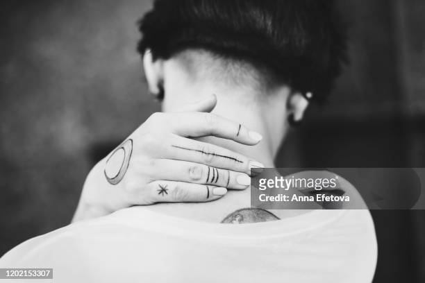 authentic young woman with tattoo on hand is standing back. - body piercings stock pictures, royalty-free photos & images