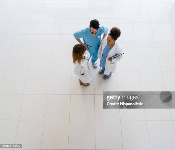 multi ethnic team of healthcare professionals discussing something at the hospital - high angle view - healthcare and medicine from above stock pictures, royalty-free photos & images