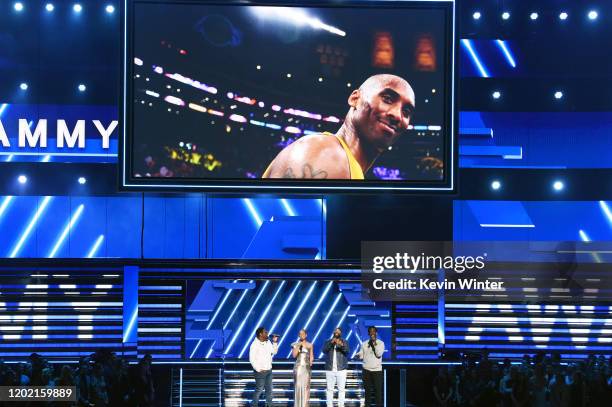 An image of the late Kobe Bryant is projected onto a screen while host Alicia Keys and Nathan Morris, Wanya Morris, and Shawn Stockman of music group...