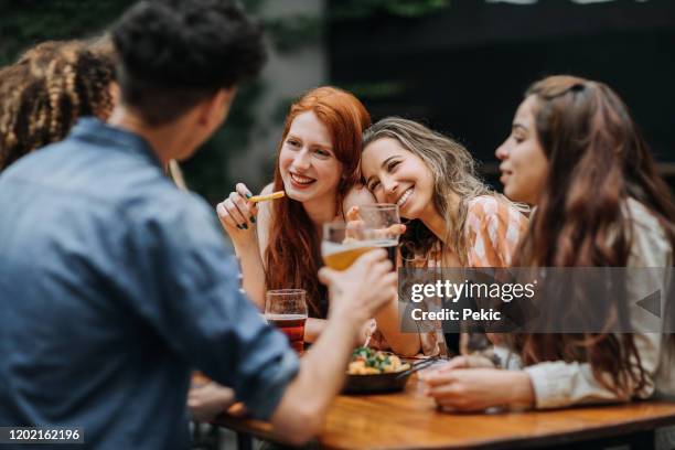 multi-ethnic group of hipster people sitting at table in brewery and having a few beers - outdoor brewery stock pictures, royalty-free photos & images