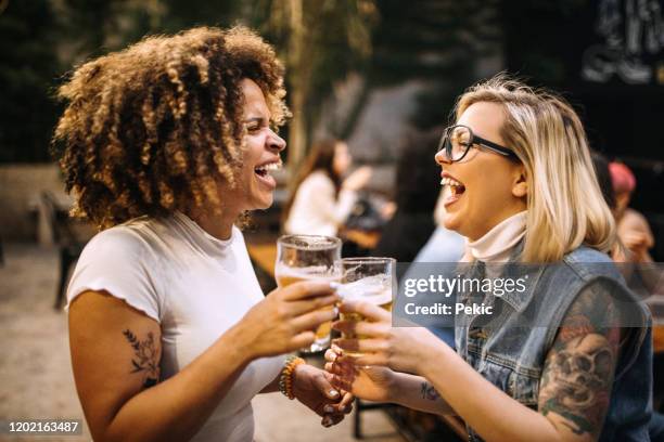 vriendinnen die bier bij de partij drinken - bier brouwen stockfoto's en -beelden