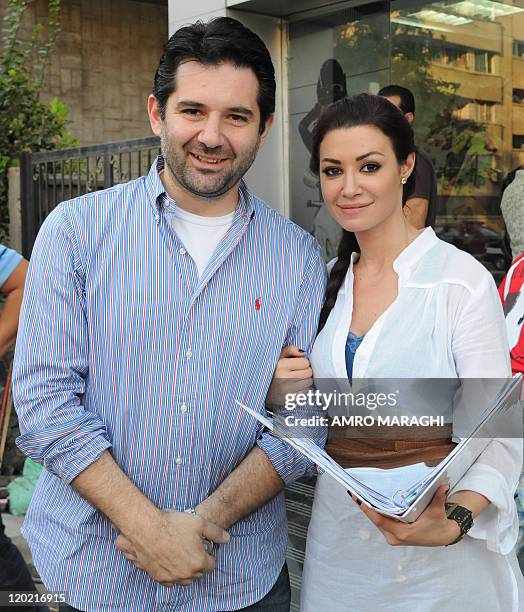 Egyptian actress Arwa poses with director isman Abu Laban as they film the television series Citizen X, on July 22 in Cairo. AFP PHOTO/AMRO MARAGHI