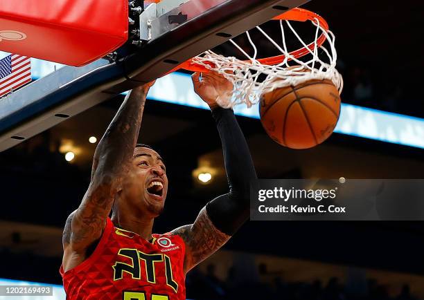 John Collins of the Atlanta Hawks dunks against Davis Bertans of the Washington Wizards in the second half at State Farm Arena on January 26, 2020 in...