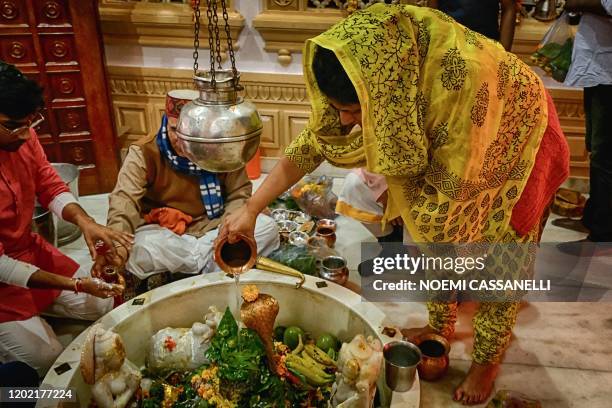 Devotee pours water on a Shiva Lingam, a stone sculpture representing the phallus of the Hindu God Lord Shiva, during the 'Maha Shivaratri' festival...