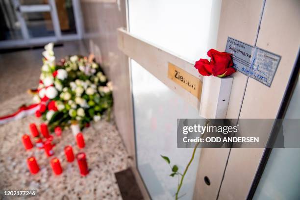 Rose is seen on the door handle at the entrance to Arena Bar and Kiosk placed there for the victims of the Hanau shooting next to a police crime...