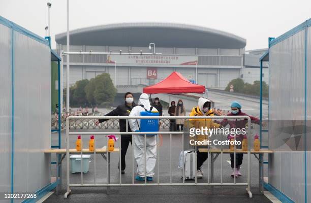 Cured Chinese patients who were infected with the new coronavirus are disinfected before leaving a Fangcang mobile cabin hospital in Wuhan City,...