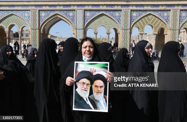 Iranians hold portraits of former and current Supreme Leaders, Ayatollah Ruhollah Khomeini and Ayatollah Ali Khamenei, as they queue up to vote...