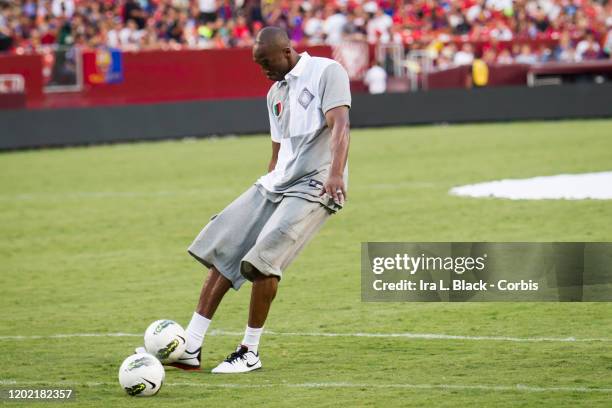 Los Angeles Lakers legend Kobe Bryant kicks the ball and takes a shot on goal the during the halftime session with him kicking some soccer balls...