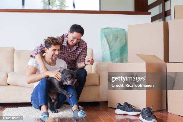 lgbt couple moving to their new home - hispanic gay man stock pictures, royalty-free photos & images