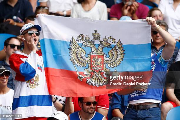 Russian fans hold up a Russian flag in support for Daniil Medvedev of Russia during his Men's Singles fourth round match against Stan Wawrinka of...