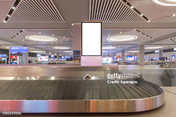 blank billboard at baggage claim - premiere of winterstone pictures deserted arrivals stockfoto's en -beelden