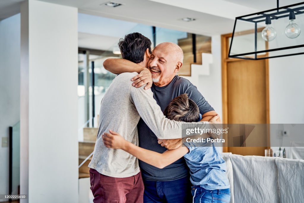 Happy multi-generation family embracing at home
