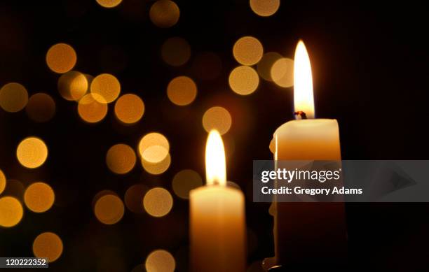 candles burning in front of out of focus lights - bougie photos et images de collection