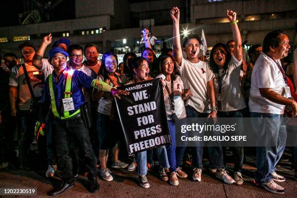 Supporters and employees of ABS-CBN, the country's largest broadcast network, shout slogans as they join a protest in front of the ABS-CBN building...