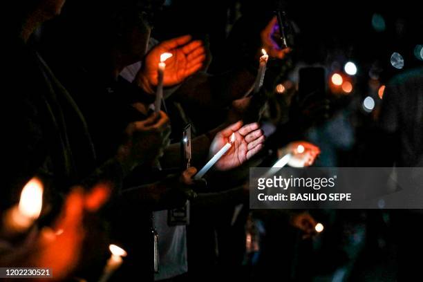 Supporters and employees of ABS-CBN, the country's largest broadcast network, hold candles as they join a protest in front of the ABS-CBN building in...