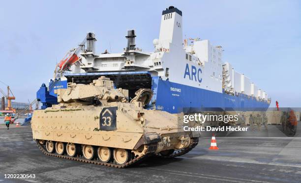 Military personnel unload Bradley Infantry Fighting Vehicle tanks from the U.S. 2nd Brigade Combat Team, 3rd Infantry Division, at Bremerhaven port...