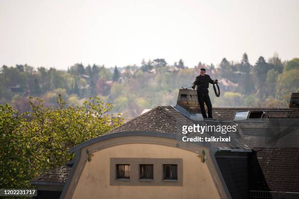 chimney sweep cleans a chimney - chimney sweeping stock pictures, royalty-free photos & images
