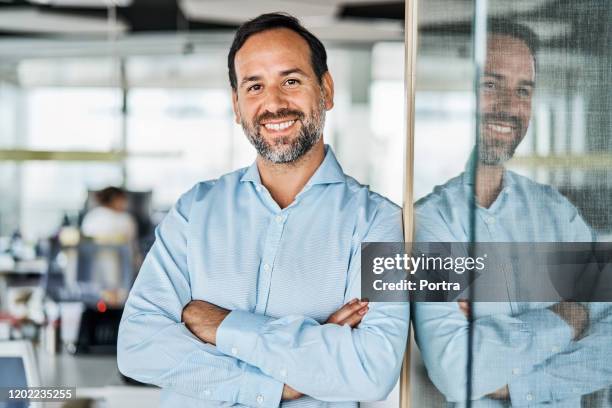 zuversichtlicher geschäftsmann im büro - glass business man stock-fotos und bilder