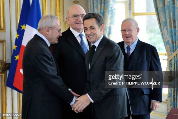 Le président Nicolas Sarkozy serre la main du nouveau membre du Conseil constitutionnel Jacques Barrot sous le regard des deux autres nouveaux...