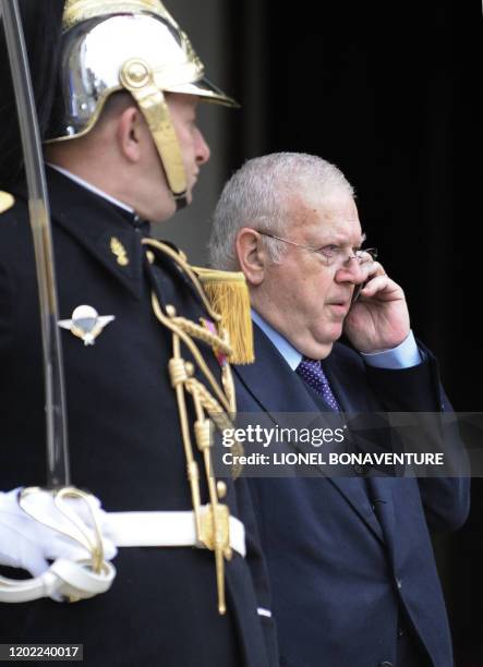 Le nouveau membre du Conseil constitutionnel Michel Charasse téléphone à sa sortie du palais de l'Elysée, le 12 mars 2010 à Paris, après avoir prêté...