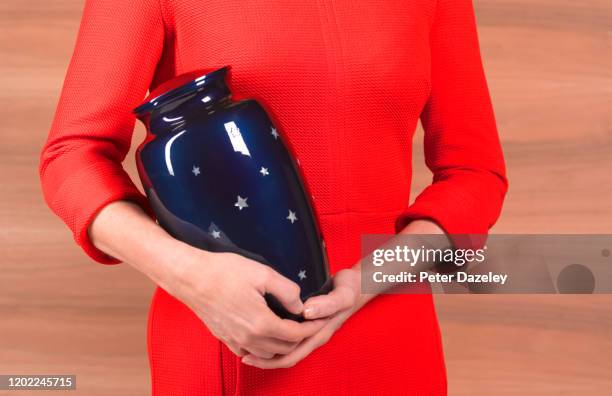 woman with funeral urn - crematie stockfoto's en -beelden
