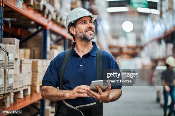 mature worker using digital tablet at warehouse - trabalhador de armazém imagens e fotografias de stock