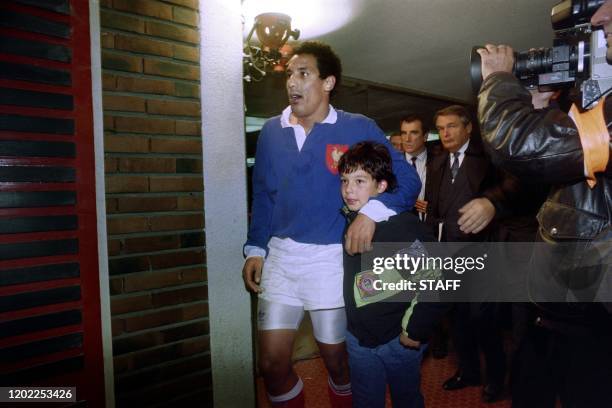 Le capitaine de l'équipe de France Serge Blanco rentre déçu aux vestiaires du Parc des Princes, accompagné par son fils, après la défaite du XV de...