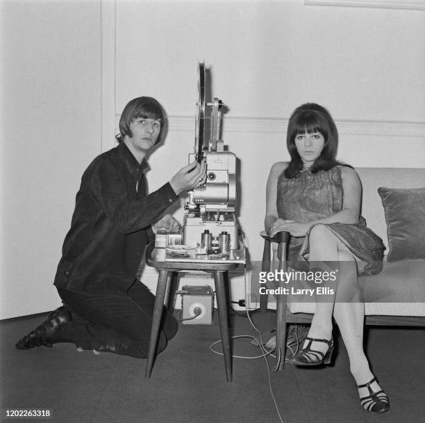 English musician Ringo Starr, drummer with The Beatles, operates a Siemens 16mm cine projector with his wife Maureen Starkey in London on 12th June...