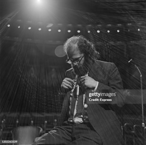 American beat poet Allen Ginsberg seated on stage during a rehearsal prior to appearing at the International Poetry Incarnation at the Royal Albert...